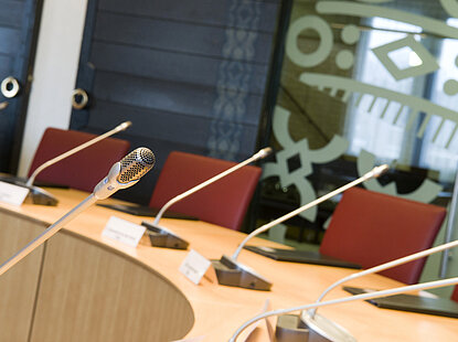 Foto genomen in de raadszaal van Someren waarop een tafel, stoelen en microfoons te zien zijn